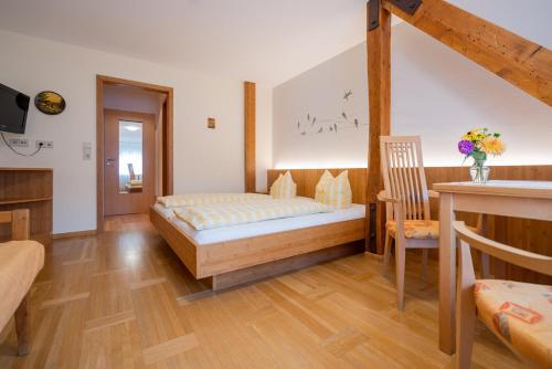 a bedroom with a bed and a chair in a room at Gasthaus-Pension Zum Kreuz in Stühlingen