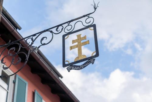 a sign on the side of a building with a cross at Gasthaus-Pension Zum Kreuz in Stühlingen