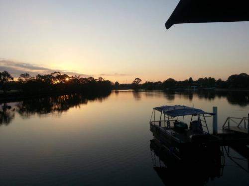 a boat docked on a river at sunset at Nightcap at Northern Grounds in Maroochydore