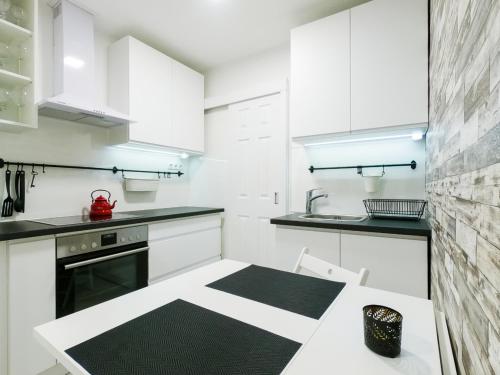 - une cuisine avec des placards blancs et un sol noir et blanc dans l'établissement Malasits Art Home, à Győr