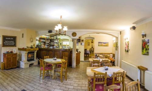 restauracja ze stołami i krzesłami oraz kominkiem w obiekcie Penzion U Candru w mieście Vyšší Brod