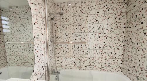 a bathroom with a shower and a bath tub at Les Aigrettes in Saint-Gilles-les-Bains