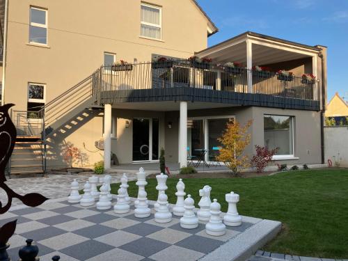 a giant chessboard in front of a house at Maison d hotes Coeur de Village Alsace & spa in Rohrwiller