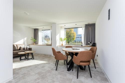 a living room with a table and chairs at Hotel de Rousch - 4 sterren Superieur in Heerlen