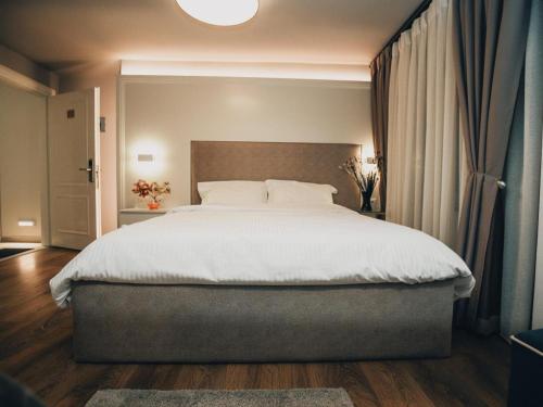a bedroom with a large bed with a white bedspread at Hotel Romeo in Korçë