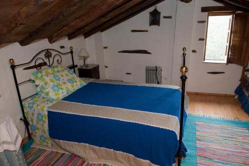 1 dormitorio con 1 cama azul en una habitación en Talasnal Casa da Urze AL, en Lousã