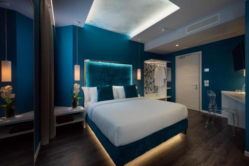 a bedroom with a large bed and a blue wall at Hotel Locanda Al Piave ***S in San Donà di Piave