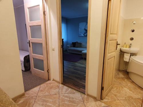 baño con aseo, lavabo y puerta en Shokolade, en Ventspils