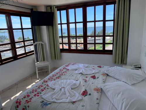 a bedroom with a bed with a dress on it at Ver a Vista Hotel in Araruama