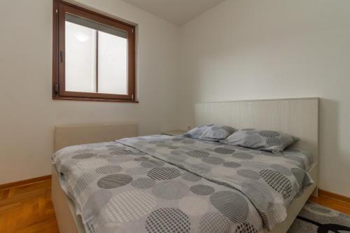um quarto com uma cama grande e uma janela em Apartman Nađa em Zlatibor