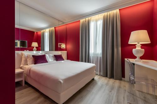 a bedroom with a large bed and red walls at Hotel Locanda Al Piave ***S in San Donà di Piave