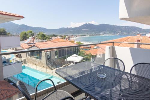 a balcony with a table and a swimming pool at Ntinas Filoxenia Hotel & Spa in Skala Potamias