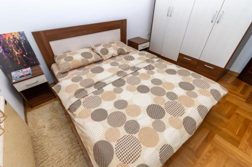 ein Schlafzimmer mit einem Bett mit einer braunen und weißen Bettdecke in der Unterkunft Apartman Nex in Zlatibor