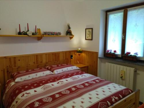 een bed in een kamer met 2 ramen bij LA CASA DI PUFFY in Selvino