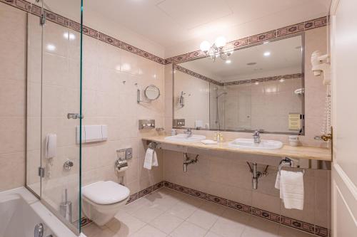 
a bathroom with a shower, sink, and toilet at Grandhotel Pupp in Karlovy Vary
