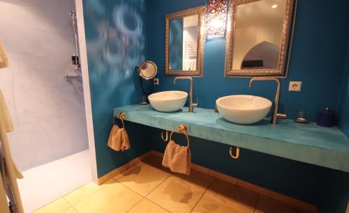 niebieska łazienka z 2 umywalkami i lustrem w obiekcie B&B Oa6 Casa w mieście Oberfeulen
