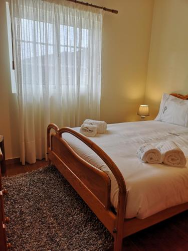 a bedroom with a large bed with towels on it at Casa de Bouças in São Pedro