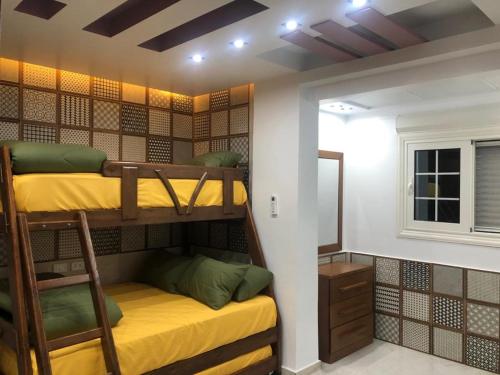 a bunk bed room with two bunk beds and a window at شقه فندقيه in Cairo