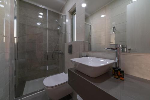a bathroom with a sink and a shower and a toilet at Mistrali Suites & Apartments in Kalyves