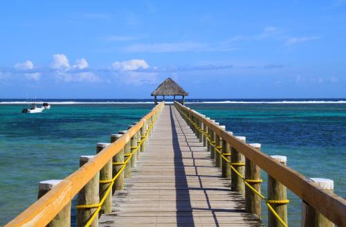 a wooden pier stretches out into the ocean at Sea Winds Villas in Singatoka