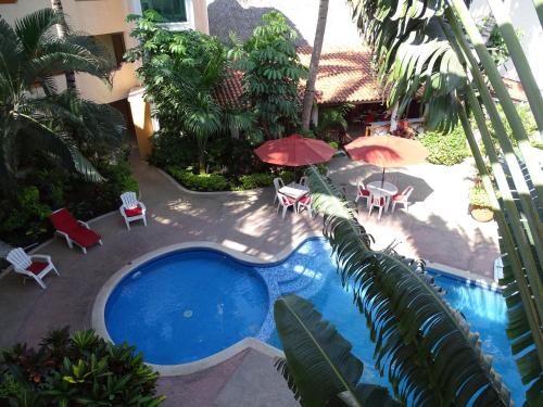 an overhead view of a swimming pool with chairs and umbrellas at Hotel Palapa Palace in Tuxtla Gutiérrez