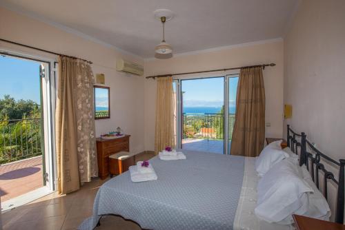 a bedroom with a bed with a view of the ocean at Villa Lenio Perithia Loutses in Perítheia