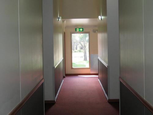 an empty hallway with a door and a window at Forbes Victoria Inn in Forbes