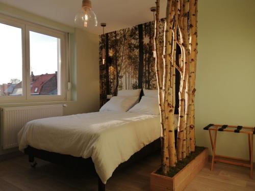een slaapkamer met een bed met een boomhoofdeinde bij Maison avec garage, terrasse, l'Herboristerie in Béthune