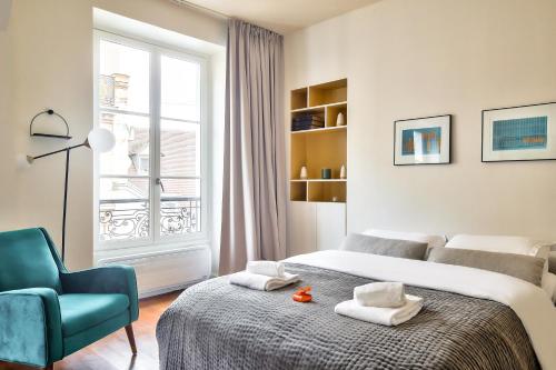 une chambre avec un lit, une chaise et une fenêtre dans l'établissement The Perfect Parisian Flat Bd St-Germain - Mid Term, à Paris