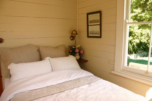 Cama en habitación con ventana en Bluff Hill Bed & Breakfast, en Napier