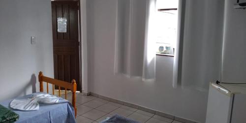 a room with a bed and a window and a refrigerator at Pousada São Francisco in Morretes