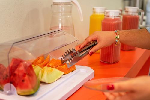 a woman is cutting up fruit with a juicer at Exclusive Hotel in Petrolina