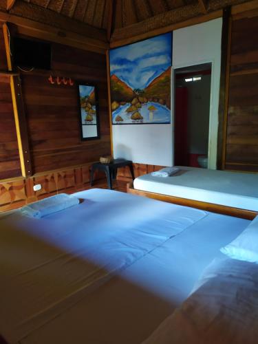 a room with two beds in a room with at Hostal Recuerdos del Tayrona in El Zaino