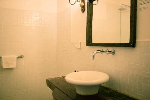 Baño blanco con lavabo y espejo en Estancia La Cinacina en San Antonio de Areco