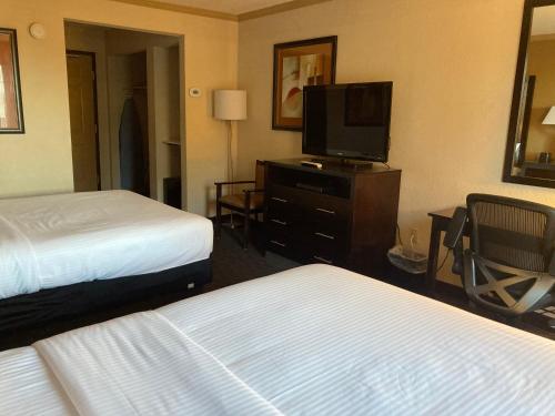 a hotel room with two beds and a flat screen tv at La Quinta by Wyndham Davis in Davis