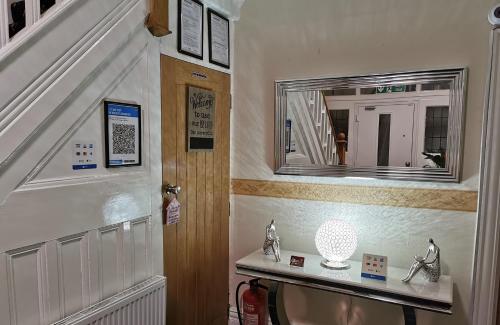 a hallway with a mirror on the wall and a staircase at Sunnydale in Blackpool