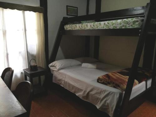 a bedroom with two bunk beds and a window at Casa Irazu in Cartago