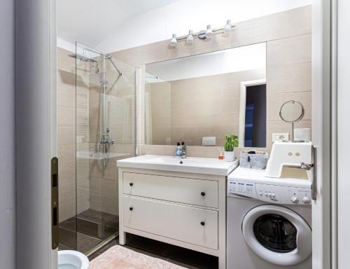 a bathroom with a washing machine and a sink at Apartament Agnes in Braşov