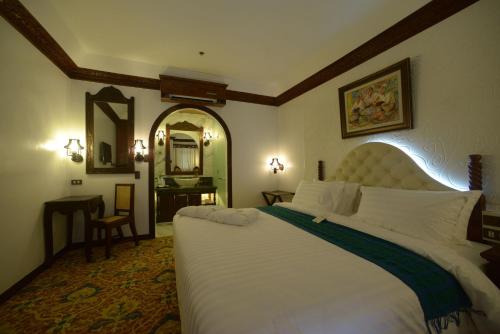 a bedroom with a large bed and a mirror at Hotel Luna in Vigan
