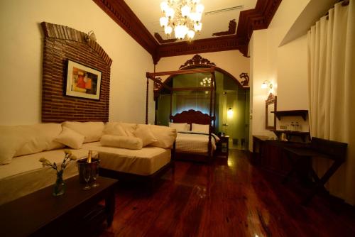 a living room with a couch and a bed at Hotel Luna in Vigan