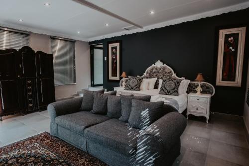 a living room with a couch and a bed at Le Grant Guesthhouse in Kroonstad