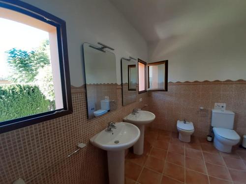 une salle de bain avec deux lavabos et un WC et une fenêtre dans l'établissement Villa Martí, à Calp