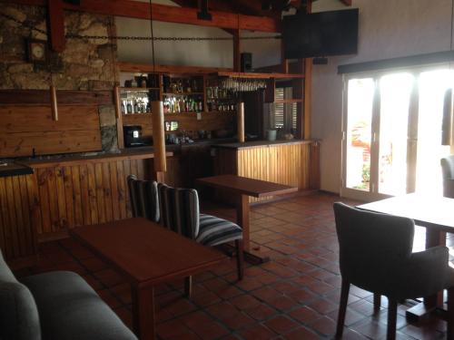 a restaurant with tables and chairs and a bar at Casa Alta Hotel Boutique & Spa - Solo Adultos in Villa Carlos Paz