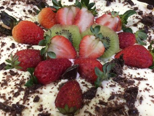 a cake with strawberries on top of it at Pousada Recanto Feliz in Penha