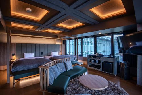 AN-GRANDEホテル奈良 في نارا: غرفة نوم بسريرين وتلفزيون وأريكة