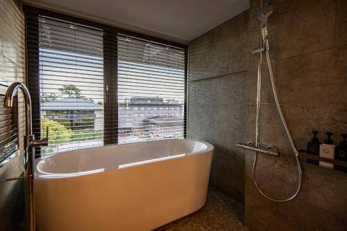 a bath tub in a bathroom with a window at AN-GRANDEホテル奈良 in Nara