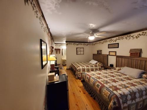 a bedroom with two beds and a desk with a lamp at Jamesport Inn in Jamesport
