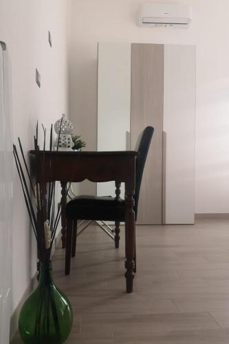 a piano and a green vase in a room at Casa Midori in Lecce