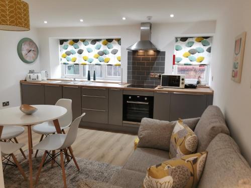 a kitchen and living room with a couch and a table at The Barn in Swaffham