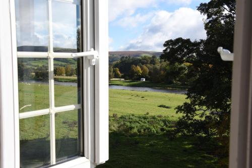 an open window with a view of a green field at The Llanelwedd Arms Hotel in Builth Wells